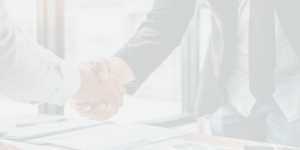 Close-up of a professional handshake over a desk with documents, symbolizing trust and collaboration in the insurance industry.